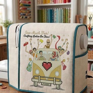 May include: A beige sewing machine cover with teal piping featuring a graphic of a yellow van with people inside and the text Sew Much Fun! Crafting Ladies On Tour! and 7 LADIES on the license plate. The cover has a side pocket and a dial.