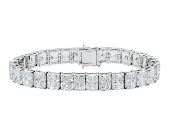 Op de afbeelding: Een zilverkleurige tennisarmband met een doorlopende rij rechthoekige, smaragdgeslepen heldere stenen in een metalen zetting. De armband is voorzien van een veilig bakslot in het midden, wat zorgt voor een uniform en symmetrisch ontwerp.