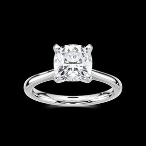May include: A solitaire engagement ring with a large, square-cut diamond set in a polished, silver band. The diamond is clear and sparkling, with four prongs securing it. The ring is displayed against a black background.
