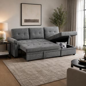 Pode incluir: Um sofá seccional cinza com otomana retrátil e compartimento de armazenamento. O sofá tem encosto e almofadas do assento com tufos. Uma almofada decorativa com um padrão circular é visível dentro do compartimento de armazenamento. O sofá está sobre um tapete bege.