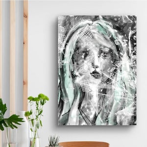 Puede incluir: Impresión artística abstracta que presenta un retrato de mujer. La obra de arte es principalmente en escala de grises con acentos de color turquesa y blanco, creando un efecto texturizado y etéreo. El rostro de la mujer es el punto focal.