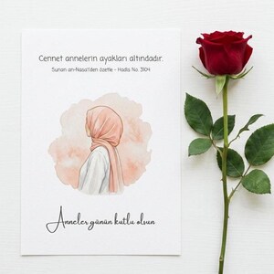 Puede incluir: Una tarjeta de felicitación con una ilustración en acuarela de una mujer con hiyab y una rosa roja. La tarjeta tiene texto en turco, incluyendo "Feliz Día de la Madre". La rosa tiene hojas verdes y un largo tallo.