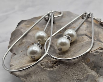 Orecchini a cerchio con perle pendenti, orecchini pendenti minimalisti in argento, gioielli scultorei di grande impatto.
