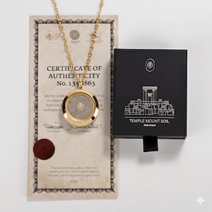 May include: A gold-colored necklace with a circular pendant containing grey soil, displayed with a certificate and a black box labeled "TEMPLE MOUNT SOIL". The certificate includes text about authenticity and the soil's origin.