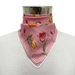 May include: A pink square scarf featuring a floral pattern of red, yellow, and orange tulips with green stems and leaves. The scarf has a white border with pink stripes and the word Kenzo printed in a cursive script near the bottom corner.