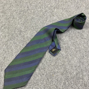 May include: A striped tie in shades of green and blue. The tie features a repeating pattern of diagonal stripes. The tie is made of a woven fabric and is rolled up at the end. The label reads "Fendi".