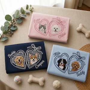 May include: Three rectangular blankets in pink, navy blue, and light blue, each featuring an embroidered double heart locket design. The embroidery depicts portraits of cats and dogs with names like Luna, Chloe, Buddy, Cooper, Milo, and Teddy.
