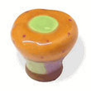 May include: A ceramic knob with a rounded, mushroom-like shape. The knob is painted in shades of orange, green, and purple. The top of the knob has a green circle in the center.