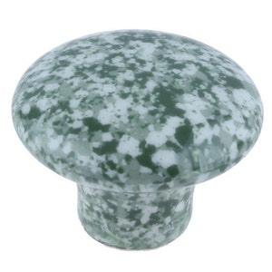 Pode incluir: Um puxador de armário em forma de cogumelo com um padrão salpicado em tons de verde e branco. O puxador tem um topo arredondado e uma base cilíndrica, adequado para ferragens de móveis.