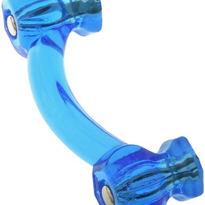 May include: A blue glass cabinet pull with a curved shape and two round knobs. The knobs have a textured surface and a silver metal accent.