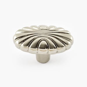 May include: A silver oval cabinet knob with a decorative, scalloped design.