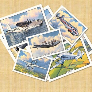 Könnte beinhalten: Eine Sammlung rechteckiger Karten mit detaillierten Illustrationen historischer Flugzeuge im Flug. Die Karten zeigen verschiedene Maschinen, darunter ein Wasserflugzeug mit der Kennung G-AFCU, einen Doppeldecker mit G-AEJM sowie Military Envoy und Flying Wing.