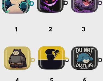 Pode incluir: Seis capas protetoras quadradas para auriculares sem fios, cada uma com gráficos de personagens distintos. Os designs incluem Snorlax, Gengar e Pikachu em cores como azul-petróleo, preto, roxo e amarelo. A capa seis inclui o texto DO NOT DISTURB.