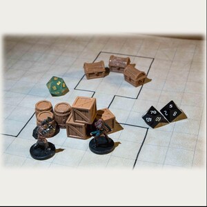Puede incluir: Una escena de juego de mesa con piezas de juego en miniatura. Hay cajas de madera, barriles y cofres del tesoro. Dos figuras en miniatura est&aacute;n situadas cerca de las cajas. Tambi&eacute;n hay dos dados negros y un dado verde de 20 caras.