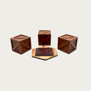Puede incluir: Cuatro cajas de madera en miniatura y una plataforma hexagonal de madera. Las cajas son marrones con detalles en marr&oacute;n oscuro y soportes en forma de cruz. La plataforma es de color marr&oacute;n claro con un cuadrado marr&oacute;n oscuro en el centro.