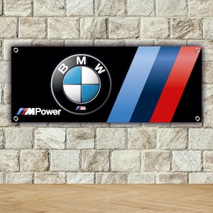 May include: Black rectangular banner featuring the BMW logo and the M Power emblem. The BMW logo is a silver circle with blue and white quadrants. Diagonal blue and red stripes are on the right side.