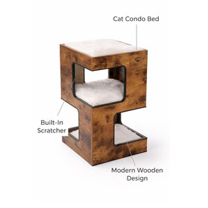 Pu&ograve; includere: Un moderno letto a condominio per gatti in legno con graffiatoio integrato. La struttura multilivello presenta una finitura marrone, con morbida biancheria da letto in peluche bianco in ogni scomparto. La parte superiore &egrave; etichettata "Cat Condo Bed".
