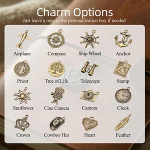May include: A collection of sixteen antique bronze-toned metal charms arranged in a grid. The charms include an airplane, compass, ship wheel, anchor, priest, tree of life, telescope, stamp, sunflower, cine camera, camera, clock, crown, cowboy hat, heart, and feather.