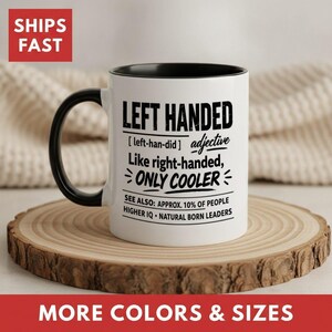 May include: A white ceramic mug with a black handle and interior, featuring black printed text that reads: LEFT HANDED [left-han-did] adjective Like right-handed, ONLY COOLER SEE ALSO: APPROX. 10% OF PEOPLE HIGHER IQ • NATURAL BORN LEADERS.