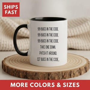 May include: A white ceramic mug with a black interior and handle, featuring black printed text that reads: 99 BUGS IN THE CODE. 99 BUGS IN THE CODE. 99 BUGS IN THE CODE. TAKE ONE DOWN, PATCH IT AROUND. 127 BUGS IN THE CODE...