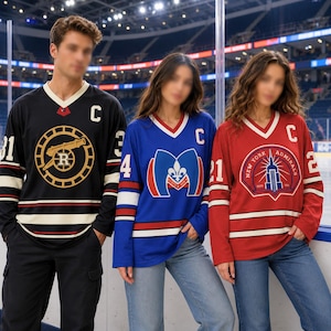 Könnte beinhalten: Drei Hockey-Trikots in Schwarz, Blau und Rot. Das schwarze Trikot hat ein goldenes Emblem mit einer Kanone und der Nummer 31. Das blaue Trikot hat ein blau-weißes Emblem mit der Nummer 4. Das rote Trikot hat ein New York Admirals-Emblem mit der Nummer 21.