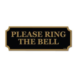 May include: A rectangular sign with rounded corners, featuring the text "PLEASE RING THE BELL" in gold lettering on a black background. The sign has a gold border and is set against a white backdrop.