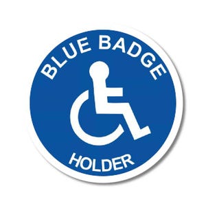 May include: A round, blue sticker with white text and a wheelchair symbol. The text reads "BLUE BADGE HOLDER" in a circular arrangement around the symbol. The sticker has a white border and is on a white background.