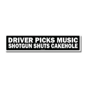 Op de afbeelding: Een rechthoekige zwart-witte sticker met de tekst "DRIVER PICKS MUSIC SHOTGUN SHUTS CAKEHOLE". De sticker heeft een witte rand en staat tegen een witte achtergrond.