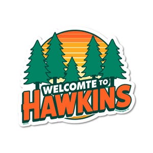 May include: A sticker with a sunset backdrop, green pine trees, and the orange text "WELCOME TO HAWKINS". The sticker has a white border and the text "stickergold co" is visible.