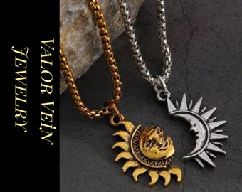 Può includere: Due collane con ciondoli celesti. Una presenta un ciondolo a forma di sole dorato, l'altra una luna crescente argentata con raggi di sole. Le collane sono esposte su una superficie scura con il testo "VALOR VEIN JEWELRY".
