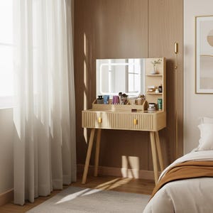 May include: A light wood vanity with a built-in illuminated mirror. The vanity has two drawers with gold-colored knobs, a shelf, and a small storage area for makeup and accessories. The legs are angled and tapered.