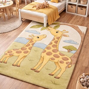 Könnte beinhalten: Rechteckiger Kinderteppich mit zwei Zeichentrick-Giraffen mit braunen Flecken auf hellgrünem Hintergrund. Der Teppich hat einen hellblauen Himmel und einen braunen Baum. Der Teppich befindet sich in einem Kinderzimmer.