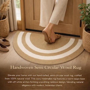 May include: Handwoven semi-circular wool rug with a warm taupe base and off-white arches. The rug is made from 100% natural wool. The rug has a semi-circular shape and is placed in front of a door.