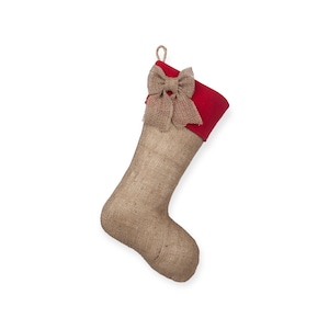 May include: A burlap Christmas stocking with a red felt cuff and a burlap bow.