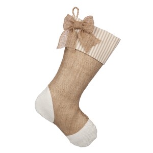 May include: A brown burlap Christmas stocking with a white and tan striped cuff and a brown burlap bow.