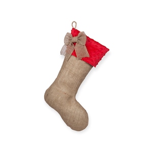 May include: A burlap Christmas stocking with a red velvet cuff and a brown burlap bow.