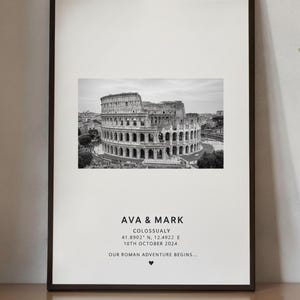 May include: Framed black and white print featuring the Colosseum in Rome. The print includes the names "AVA & MARK", coordinates, date "10TH OCTOBER 2024", and the phrase "OUR ROMAN ADVENTURE BEGINS..." with a heart symbol.