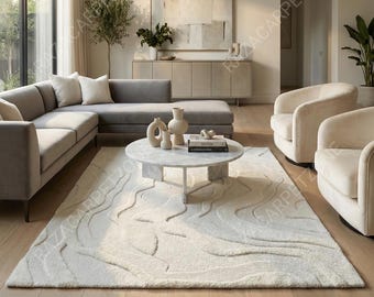May include: A modern living room featuring a large, off-white area rug with a textured, wave-like pattern. The room includes a gray sectional sofa, two cream-colored armchairs, and a marble coffee table. A large abstract painting hangs above a wooden cabinet.