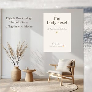 May include: A serene interior scene featuring a beige poster with the text "The Daily Reset" and "31 Days of Inner Peace." A wooden chair, a vase with dried plants, and a small table are also visible. The overall aesthetic is minimalist and calming.