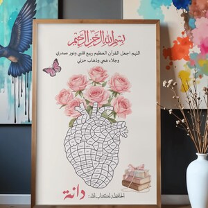 May include: A framed wall art print featuring a central anatomical heart illustration composed of small segments with Arabic text, topped with a bouquet of pink roses and a butterfly. The print includes Arabic calligraphy and a stack of books.