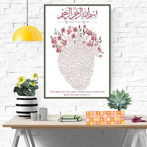 May include: A framed print with Arabic calligraphy and English text, "READ AND RISE." The artwork features a heart-shaped design filled with text, adorned with pink flowers. The bottom text reads, "THE BEST OF YOU ARE THOSE WHO LEARN THE QUR'AN AND TEACH IT."