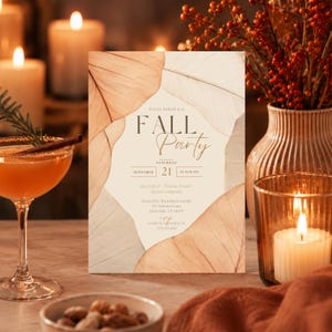 May include: A rectangular invitation card featuring a cream-colored center framed by large, translucent, tan and brown dried leaves. The text reads: You're invited to a FALL Party, Saturday September 21 at 8:00 PM, Good food, Warm drinks, Great company, Hosted by The Johnson Family, 123 Autumn Lane, Riverdale, CT 06475, RSVP to Julie by September 1st (555) 123-4567.