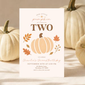 Op de afbeelding: Een rechthoekige verjaardagsuitnodiging met een crèmekleurige achtergrond en een centrale illustratie van een lichtoranje pompoen omringd door herfstbladeren. De tekst luidt: Our little pumpkin is turning TWO, Charlie's Second Birthday, 16 september om 14:00 uur, 42 Market Lane, Brooklyn, NY 11201, RSVP naar Olivia (555) 123-4567.