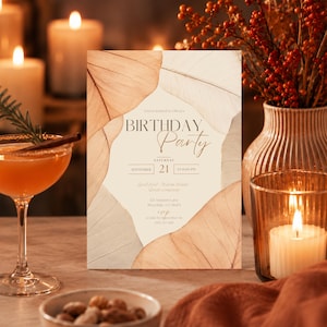 Op de afbeelding: Een rechthoekige uitnodigingskaart voor een verjaardagsfeest met een crèmekleurig midden en bruine bladafbeeldingen aan de randen. De tekst luidt: You're invited to Olivia's BIRTHDAY Party, Saturday, September 21, at 8:00 PM, 123 Autumn Lane, Riverdale, CT 06475.