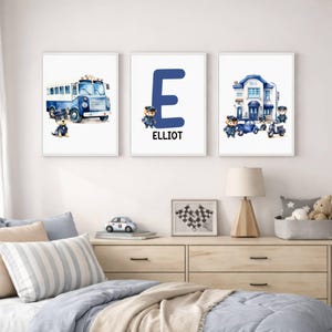 Puede incluir: Tres impresiones enmarcadas en acuarela con temática policial. Una impresión presenta un autobús azul, otra una gran letra azul "E" con el nombre "ELLIOT", y la tercera una comisaría. Cada impresión incluye un oficial de policía.