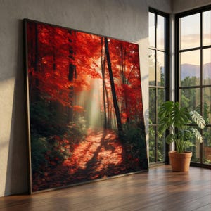 Könnte beinhalten: Ein großes, rechteckiges gerahmtes Wandbild, das einen Waldweg im Herbst zeigt. Die Szene umfasst leuchtend rote Ahornbäume, dunkle Baumstämme und einen sonnendurchfluteten, mit Laub bedeckten Pfad, durch den Lichtstrahlen dringen.