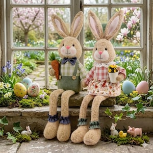 Könnte beinhalten: Zwei Plüsch-Osterhasenfiguren mit langen Beinen sitzen auf einem Steinsims. Ein Hase hält eine Karotte, der andere einen kleinen Topf mit gelben Blumen. Die Hasen tragen Outfits mit Karomustern und Blumenmustern. Ostereier und kleine Figuren schmücken die Szene.