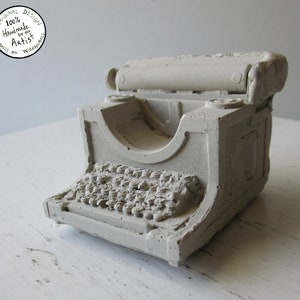 A hand made miniature sculpture of a manual type writer, cast in solid concrete, mini cement typewriter, write art gift ornament, cool handmade retro art, cast concrete garden ornament, retro modern art piece