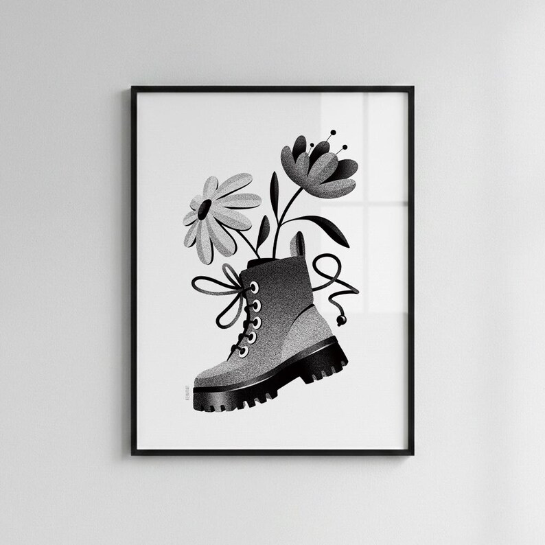 May include: A black and white digital art print featuring a stippled illustration of a lace-up combat boot with a thick lug sole. Two stylized flowers emerge from the top of the boot, with long laces extending outward in a decorative loop.