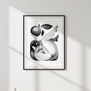 May include: Black and white art print in a black frame. The artwork depicts a stylized figure holding a fruit with a leaf. The figure has long, dark hair and is reclining. The print is mounted on a white wall.